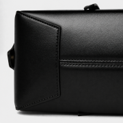 Czarna skórzana torebka damska typu baguette o wydłużonej, eleganckiej formie inspirowanej fasonem bowling bag łączy minimalistyczny design z subtelnym retro charakterem. Spód.