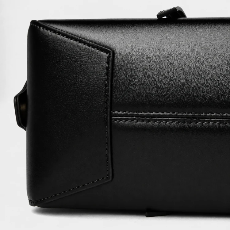 Czarna skórzana torebka damska typu baguette o wydłużonej, eleganckiej formie inspirowanej fasonem bowling bag łączy minimalistyczny design z subtelnym retro charakterem. Spód.