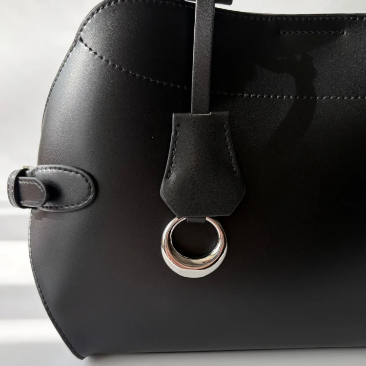 Czarna skórzana torebka damska z naturalnej skóry bydlęcej. Rączka, regulowany pasek, wnętrze z kieszeniami i wyjmowaną saszetką. Do ręki, na ramię i crossbody. Detal.